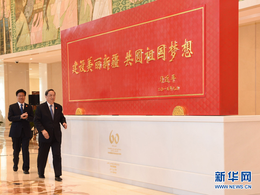 這是俞正聲和中共中央政治局委員、新疆維吾爾自治區(qū)黨委書記張春賢一同為習近平總書記題詞賀匾揭幕。新華社記者 高潔 攝 