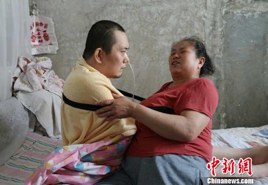 身體日漸衰老的梁青蘭每次幫兒子翻身、坐立，全身的衣物都要濕透一次?！∩忻鱾b 攝