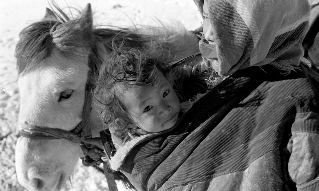 1990年3月，西藏當(dāng)雄縣納木湖鄉(xiāng)三村女牧民斯卓不畏嚴(yán)寒，懷抱幼子，準(zhǔn)備到遠(yuǎn)處放牧。新華社記者覺果攝
