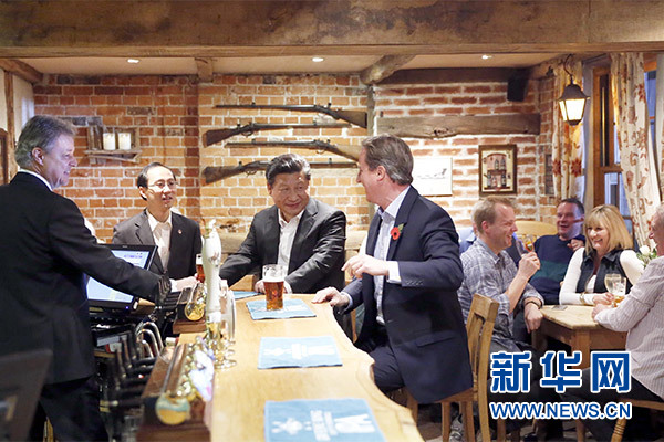 這是會晤結(jié)束后，習(xí)近平在卡梅倫陪同下乘車前往當(dāng)?shù)匦℃?zhèn)體驗(yàn)酒吧文化。新華社記者 鞠鵬 攝